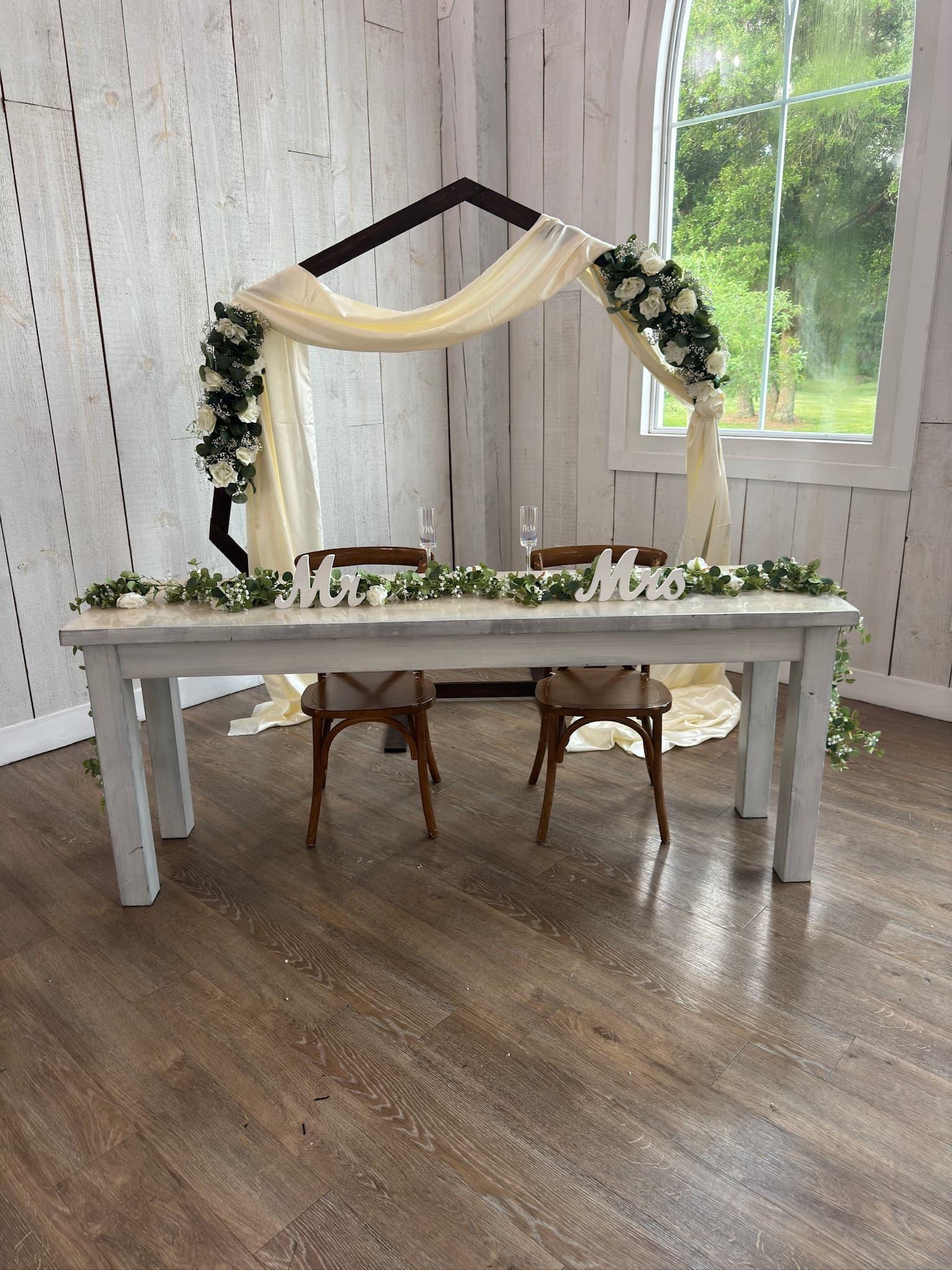 Beautifully styled ceremony space with lush floral arch and aisle decor