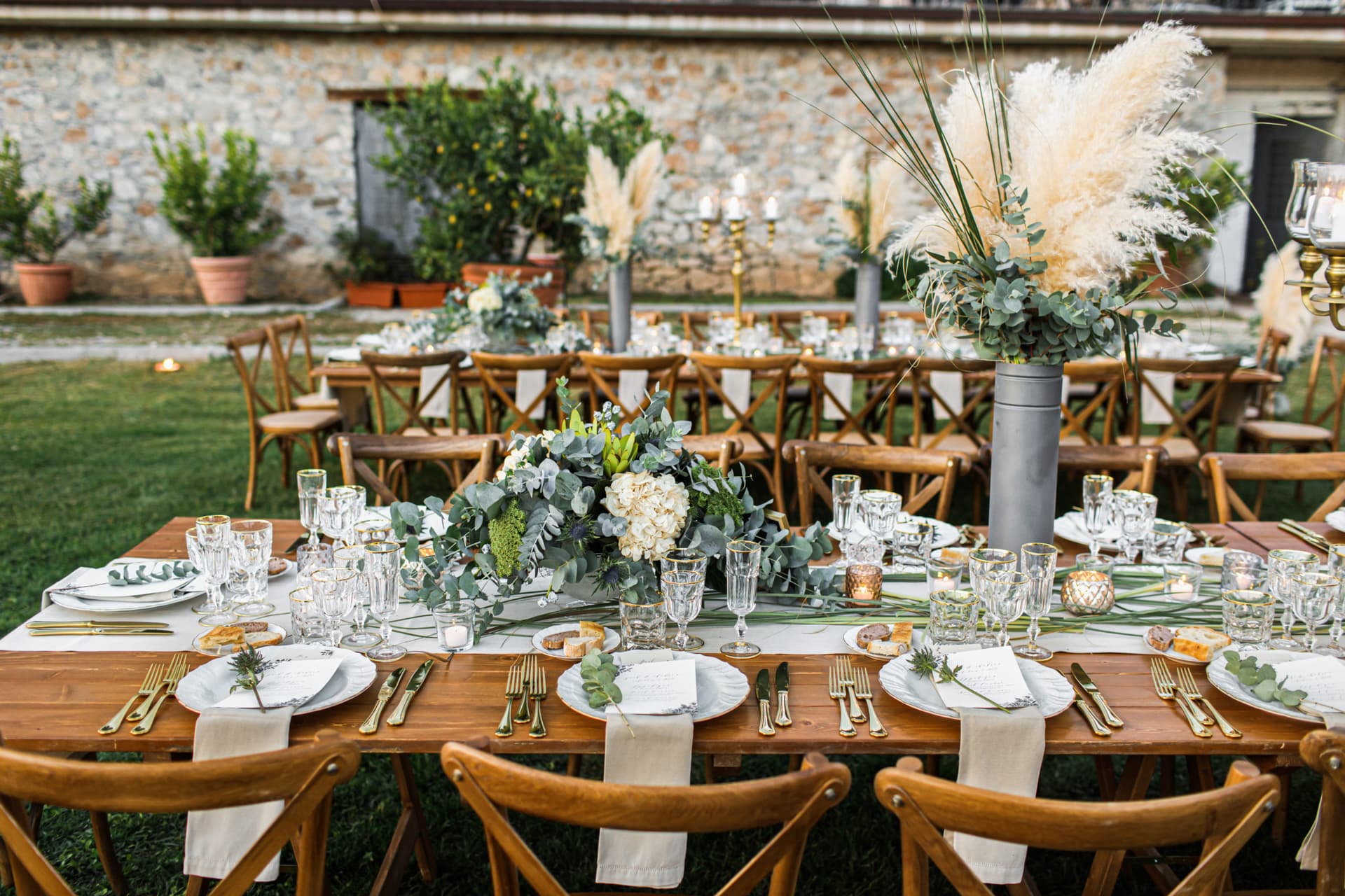 Elegantly set estate dining table with pampas grass and candlelight